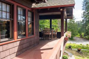 a porch of a house with a table and chairs at Ski Jump Chalet in Lake Placid