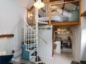 a small room with a spiral staircase and a bunk bed at Puffins Nest in Bideford