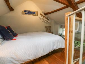 um quarto com uma cama branca num sótão em Puffins Nest em Bideford