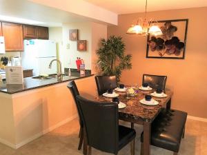 a dining room table with chairs and a kitchen at Sweet retreat condo resort in Kissimmee