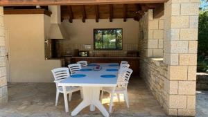 - une table et des chaises blanches sur la terrasse dans l'établissement Le Moulin du Boisset, à Saint-Denis-lès-Martel