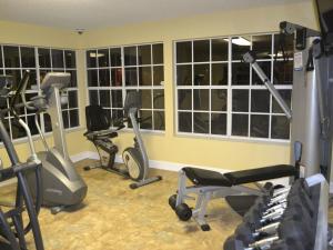 un gimnasio con varias bicicletas estáticas en una sala con ventanas en Sweet retreat condo resort en Kissimmee