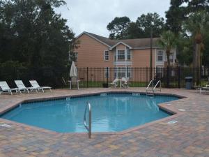 a swimming pool with two chairs and a house at Sweet retreat condo resort in Kissimmee