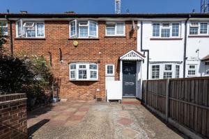 a brick house with a black door and a fence at 2 Bed House near the London Museum in London