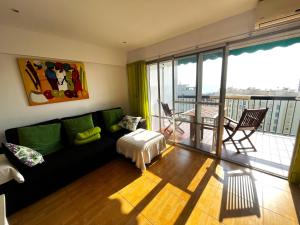 ein Wohnzimmer mit einem Sofa und einem Tisch in der Unterkunft Elegante alojamiento con piscina y terraza in Valencia