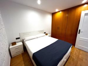 um quarto com uma grande cama branca e um armário de madeira em Elegante alojamiento con piscina y terraza em Valência