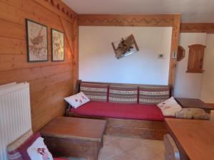 um quarto com um sofá vermelho num quarto de madeira em Appartement Méribel, 3 pièces, 4 personnes - FR-1-411-618 em Les Allues