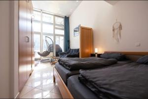a bedroom with two beds and a room with a window at Wohnwerk: Penthouse - Moselblick in Traben-Trarbach