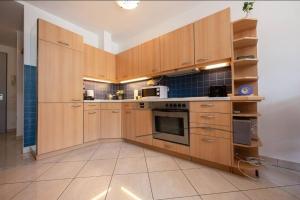 a large kitchen with wooden cabinets and appliances at Wohnwerk: Penthouse - Moselblick in Traben-Trarbach