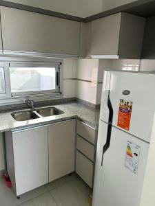 een keuken met een witte koelkast en een wastafel bij APARTAMENTO 2 DORMITORIOS (CERCANO AL CENTRO) in Cordoba