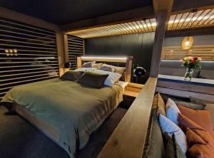 a bedroom with a bed and a bench in it at Apartman Mary Lou, Hotel Ovruc in Štrbské Pleso