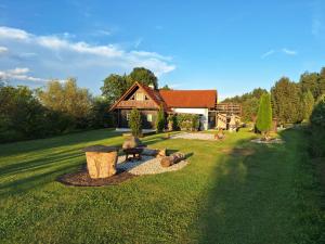 a house with a fire pit in the grass at Ferienhaus Am Bach in Kirchberg an der Raab