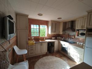 a kitchen with white cabinets and a sink at AMIRA home near Sitges in Sant Pere de Ribes
