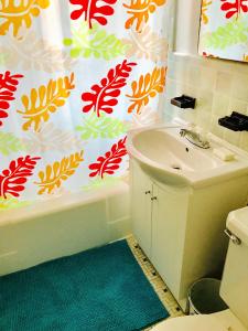 a bathroom with a sink and a toilet and a shower curtain at Stylish Montreal Apartment: Comfortable Stay in the Golden Square Mile in Montreal