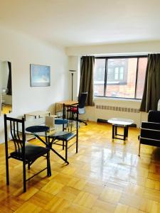 a living room with tables and chairs in a room at Stylish Montreal Apartment: Comfortable Stay in the Golden Square Mile in Montreal