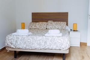 a bedroom with a bed with two towels on it at Triana Riverside Guesthouse in Seville