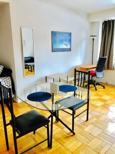 a living room with a glass table and chairs at Stylish Montreal Apartment: Comfortable Stay in the Golden Square Mile in Montreal