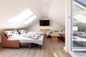 um quarto no sótão com 2 camas e uma televisão em Schlögler`s Apartmenthaus em Neustift im Stubaital