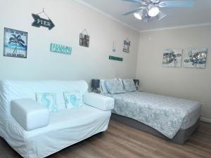 a bedroom with a bed and a white couch at Private Suite with Private Gym&Patio, Minutes to Beaches, Up to 4 Guests in Largo