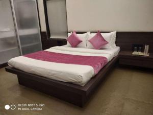 1 cama con almohadas rosas en una habitación en Forest Feels en Nashik