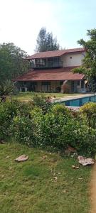 una casa con piscina frente a ella en Forest Feels, en Nashik