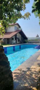 een zwembad voor een huis bij Forest Feels in Nashik