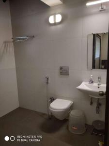 een badkamer met een toilet en een wastafel bij Forest Feels in Nashik