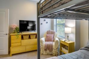 a bedroom with a bunk bed with a chair and a tv at Houston Home with Rooftop Patio Less Than 1 Mi to Aquarium! in Houston