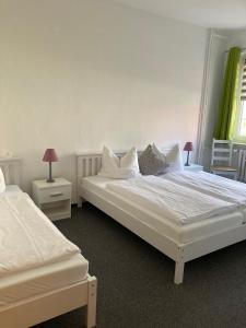 een slaapkamer met 2 bedden en 2 tafels met lampen bij Haus Brandenburg in Stechlin