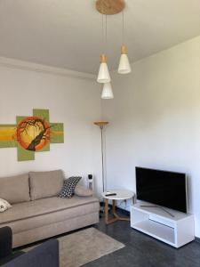 een woonkamer met een bank en een flatscreen-tv bij Haus Brandenburg in Stechlin