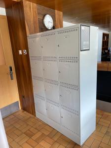 Un mucchio di armadietti con un orologio sopra. di VISPERBLICK 24-7 Parkplatz und Frühstück inkl ad Ausserberg