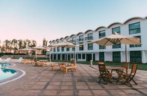 un hotel con tavoli e ombrelloni accanto a una piscina di BTH Hotel Arequipa Lake ad Arequipa