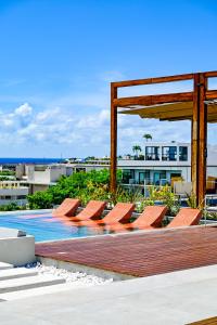 a group of chairs sitting next to a swimming pool at Aloft Playa del Carmen in Playa del Carmen