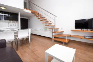 a living room with a spiral staircase and a table at Apartment Marin in Rogoznica