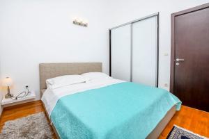 1 dormitorio con 1 cama grande con manta azul en Apartment Marin, en Rogoznica
