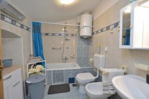 a bathroom with a toilet and a shower and a sink at Apartments Lory in Rabac