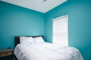 une chambre bleue avec un lit et une fenêtre dans l'établissement Buckeye Lake Cottage, à Hebron