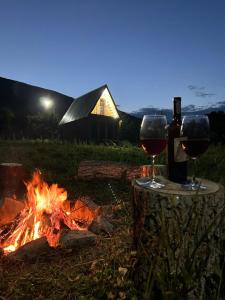 two glasses of wine sitting next to a fire at Address number 8 in Yeghegnadzor