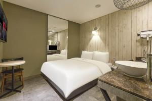 ソウルにあるHERTZ Hotelのベッドルーム(白い大型ベッド1台、シンク付)