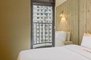 a hotel room with a bed and a window at HERTZ Hotel in Seoul