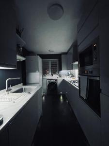 a kitchen with a sink and a washing machine at Luxury mid century Apartment in London