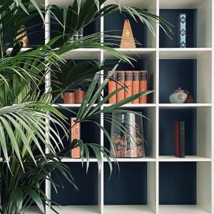 a book shelf with books and a plant in it at Luxury mid century Apartment in London