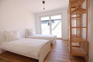 a bedroom with two beds and a book shelf at Ganzes Apartment -London- in Erftstadt - 3 Zimmer & 63qm - nahe Köln, Messe, Phantasialand & Bonn - Familienurlaub oder Business Trip in Erftstadt