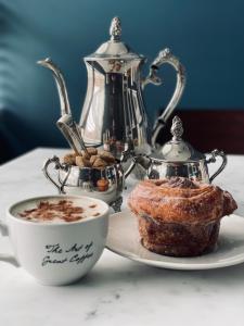 una tazza di caffè e un prodotto da forno su un piatto con teiera di Luxury mid century Apartment a Londra