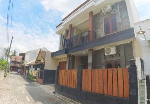 a house with a wooden fence on a street at Eltanin Homestay by FH Stay in Salakan