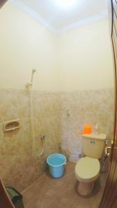 a bathroom with a toilet and a blue bucket at Eltanin Homestay by FH Stay in Salakan