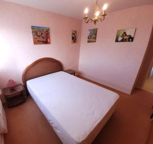 a bedroom with a white bed in a room at Le Kervenel - Les Gîtes de la Côte d'Amour in Le Croisic