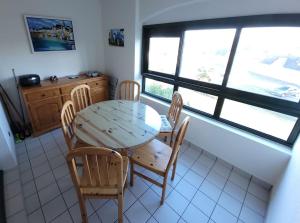 a table and chairs in a kitchen with a window at Le Kervenel - Les Gîtes de la Côte d'Amour in Le Croisic