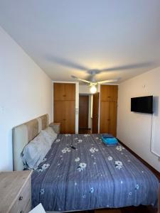 een slaapkamer met een bed met een blauw dekbed bij Departamento Cañada Completo in Cordoba