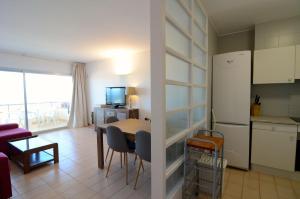 eine Küche und ein Wohnzimmer mit einem Tisch und einem Kühlschrank in der Unterkunft Puig Padro 4 1-1 in L'Escala